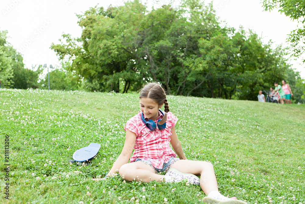 joyful girl having fun in the park with her skateboard 