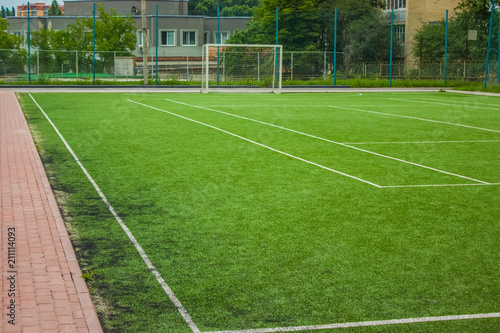 sport concept synthetic small football field green grass background texture and white marking lane with empty space for copy or text