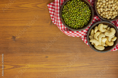 Flat lay,top view assorted beans included cashews green beans and soybeans on wooden table with copy space