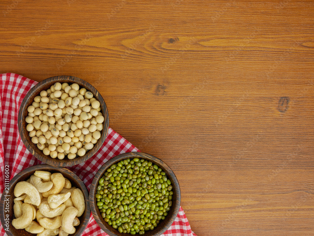 Flat lay,top view assorted beans included cashews green beans and soybeans on wooden table with copy space Flat lay,top view assorted beans included cashews green beans and soybeans on wooden table with copy space