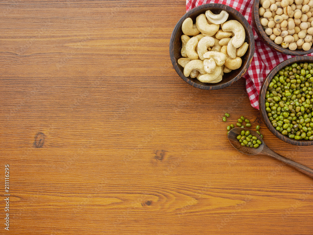 Flat lay,top view assorted beans included cashews green beans and soybeans on wooden table with copy space Flat lay,top view assorted beans included cashews green beans and soybeans on wooden table with copy space