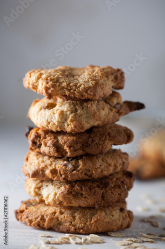 A stack of homemade oatmeal cookies on a grey background.