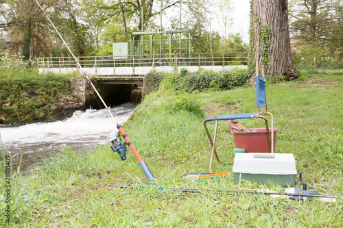 little fisherman corner at the river edge with the equipment and fishing rod