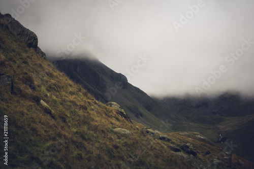 Mysterious mist and fog covers dark rolling hills in the Scottish highlands, Scotland.