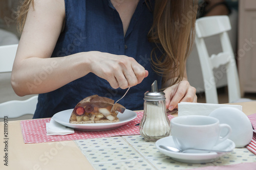 A visitor to a cafe is eating a dessert Hands, appliances, serving © biggur