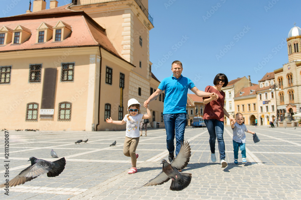 Family Running with Flying Pigeons in Street