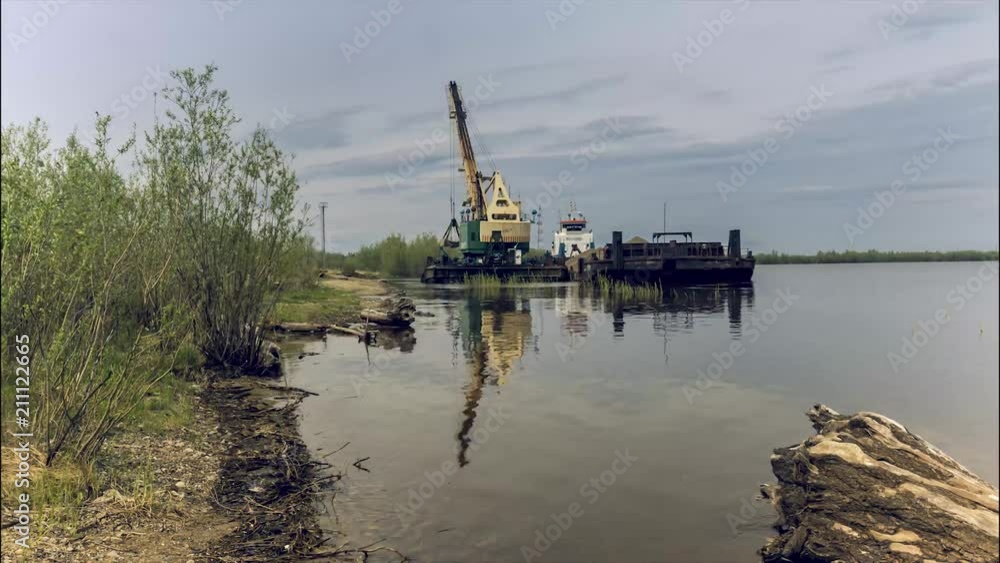 River crane in operation The river crane unloads from the barge, which approached the unloading, ashore crushed stone River crane in operation The river crane unloads from the barge, which approached the unloading, ashore crushed stone