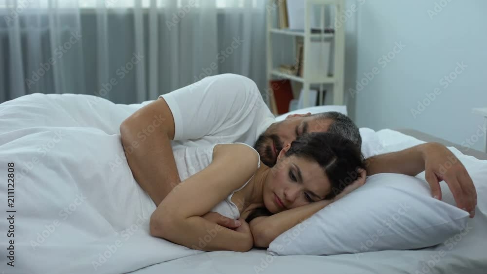 Wife thoughtfully lying in bed, woman keeping secret from her husband, remorse Wife thoughtfully lying in bed, woman keeping secret from her husband, remorse