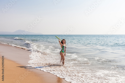 Beautiful woman with board stands in the sea with green board and laughing. Phuket, Thailand