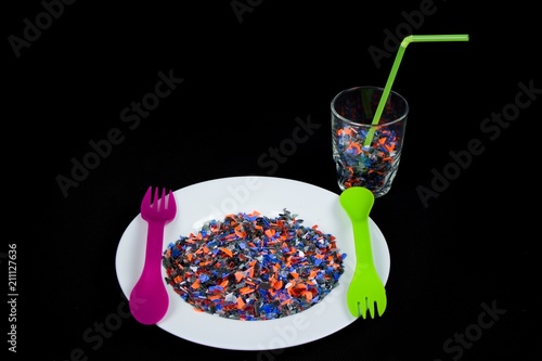 Crushed multicolored plastic pieces on white plate photo