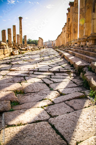 Columns and cobblestones of Cardo Maximus, an ancient Roman colonnaded road in the archaeological site of the historical city of Jerash near Amman in Jordan