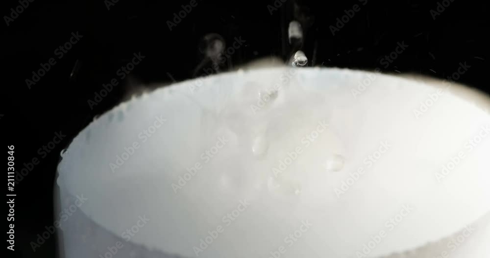 Boiling Liquid and White Smoke. A violent chemical reaction in a light bulb against a black background Boiling Liquid and White Smoke. A violent chemical reaction in a light bulb against a black background
