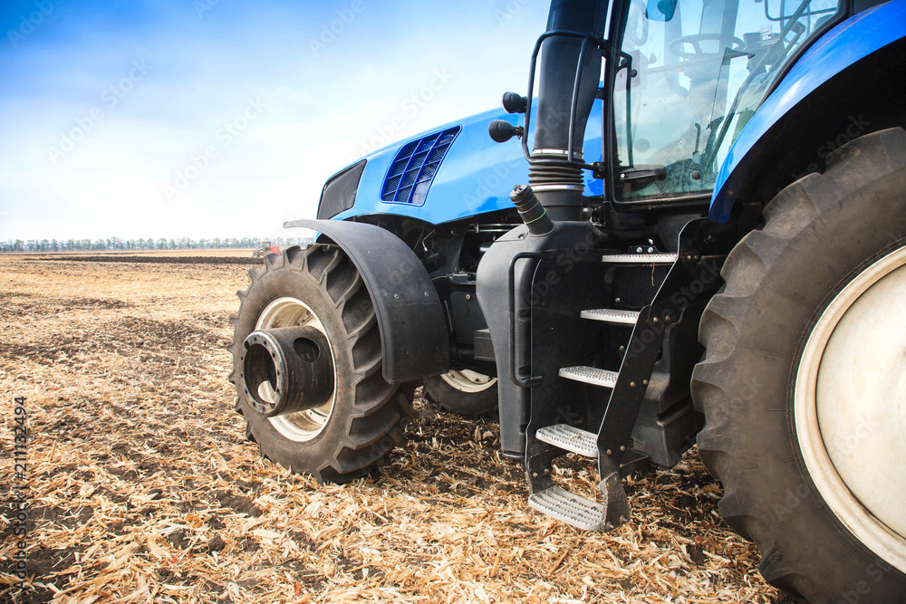 Fototapeta premium A wheel from a tractor working in the field close up. The concept of agriculture.