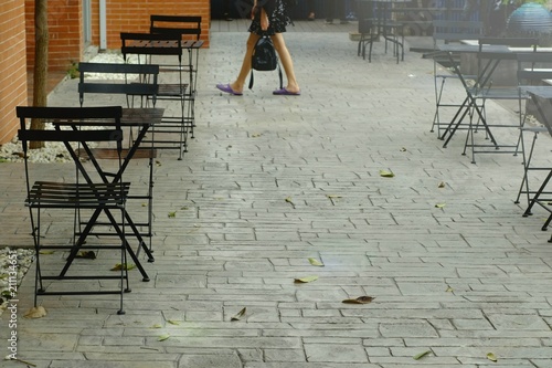 Several sets of tables and black chairs are arranged on outside terrace of shop for customers who want to get outside atmosphere of the shop.