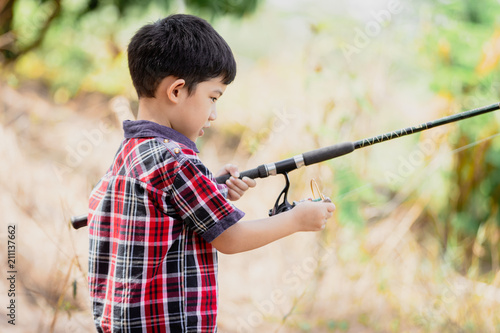 Asian young cute little boy fishing in natural