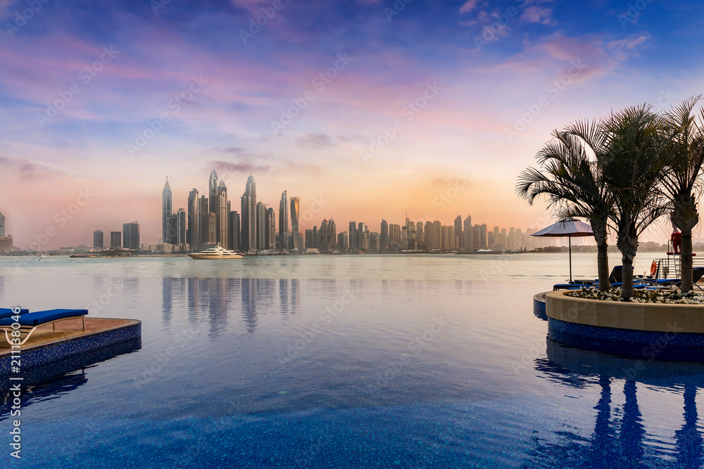 Naklejka premium Widok na Dubai Marina o zachodzie słońca z basenem na pierwszym planie