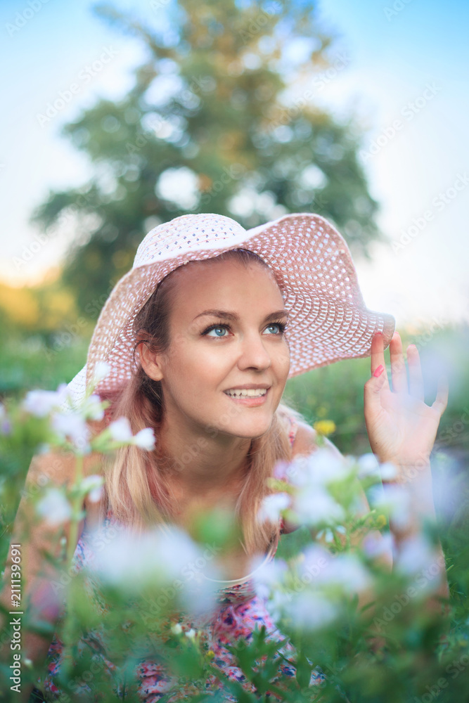 Fototapeta premium Portrait of a young woman in a hat on nature.