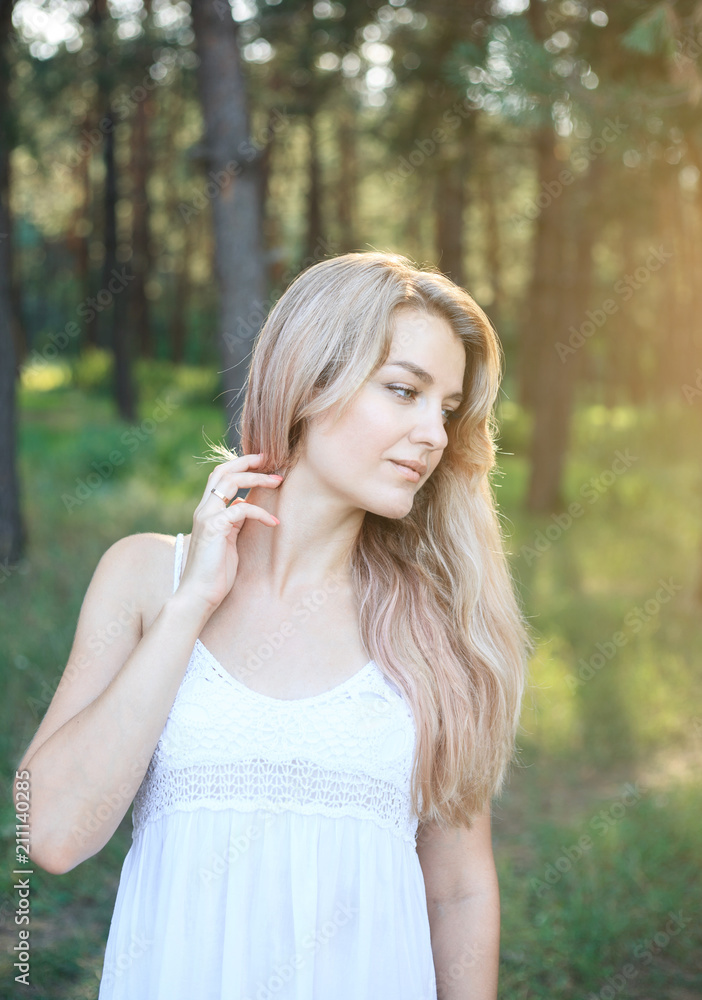 Portrait of a beautiful young woman with long hair on nature.