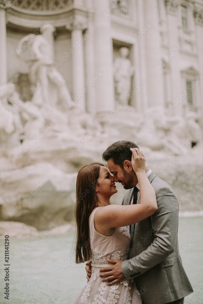 Bride and groom posing in front of Trevi Fountain (Fontana di Trevi), Rome, Italy Bride and groom posing in front of Trevi Fountain (Fontana di Trevi), Rome, Italy