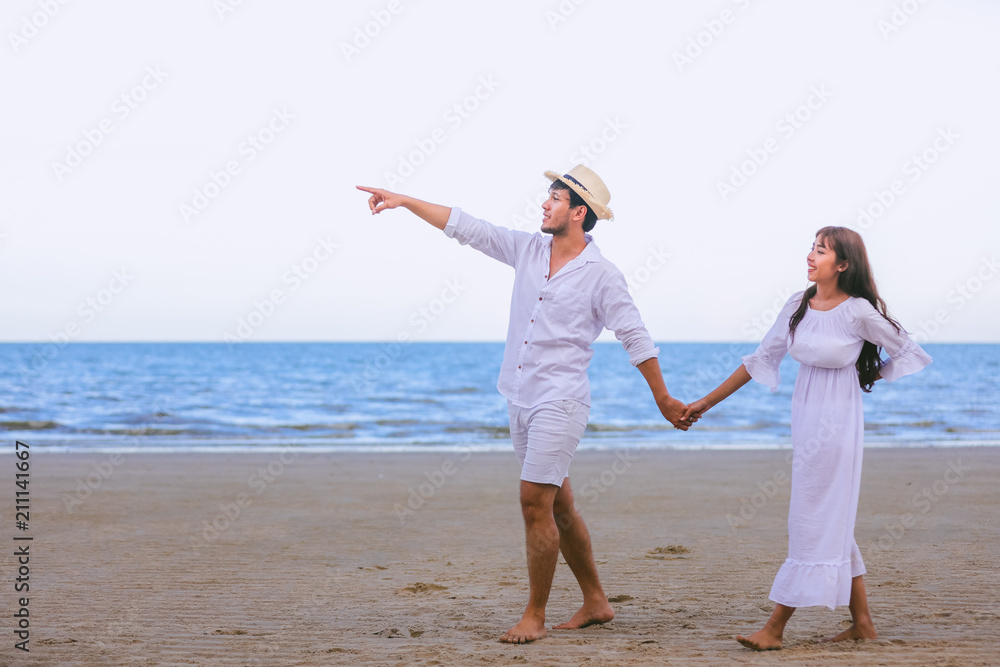 Happy Romantic Couples lover holding hands together walking on the beach Happy Romantic Couples lover holding hands together walking on the beach