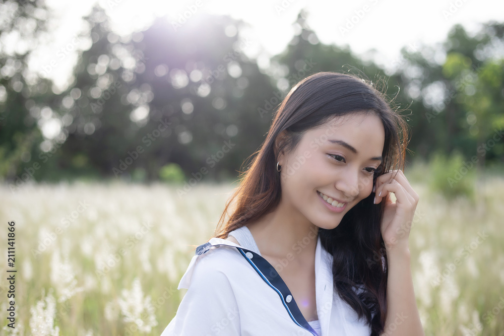 Asian women happy smile on relaxing time at the meadow and grass