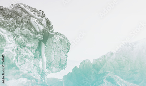 Cold blue toned image of a woman mountain climbing