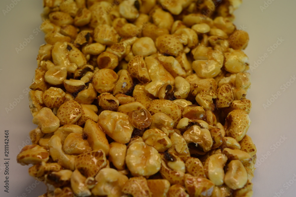 On a white paper background is located and placed from a delicious and sweet grilling of air corn kernels, popcorn with caramel On a white paper background is located and placed from a delicious and sweet grilling of air corn kernels, popcorn with caramel