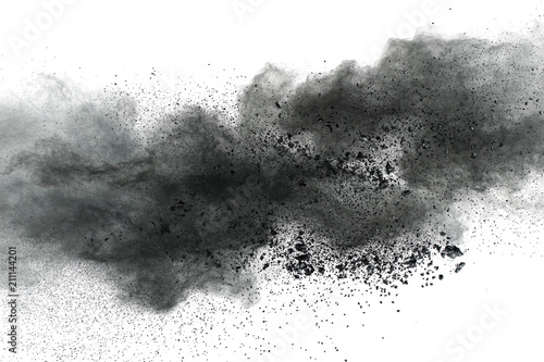 Black powder explosion against white background.Closeup of black dust particles explode isolated on white background.