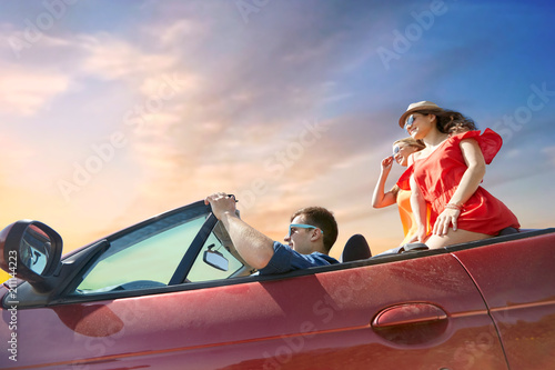summer holidays, road trip and travel concept - happy friends driving in convertible car over sky background © Syda Productions