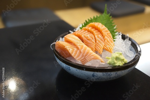  Japanese cuisine with copy space, Raw Salmon Sashimi with Wasabi on black bowl. A restaurant Scene for background.