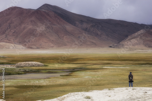 The man stand look for water in Mountain meadow in front of Mountain In Leh ladakh
