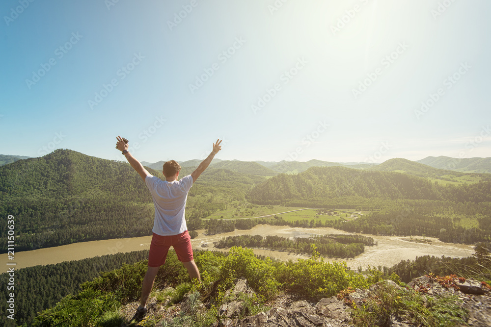 Man standing on top of cliff in summer beauty day in Altai mountains Man standing on top of cliff in summer beauty day in Altai mountains