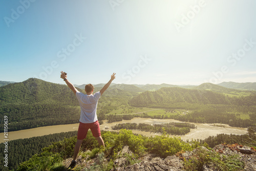 Man standing on top of cliff in summer beauty day in Altai mountains