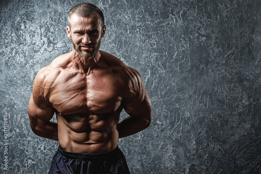 Strong and muscular bodybuilder showing his body