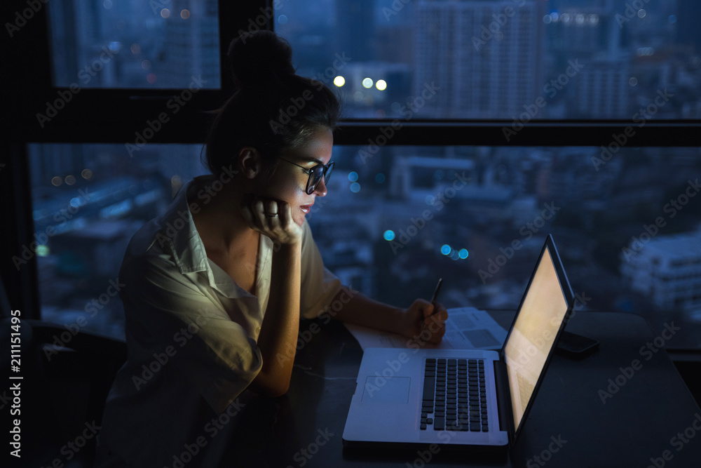 Woman is working with laptop at home during night. - obrazy, fototapety, plakaty 