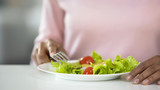 Woman eating vegetable salad close-up, healthy eating habits, high-fiber dieting