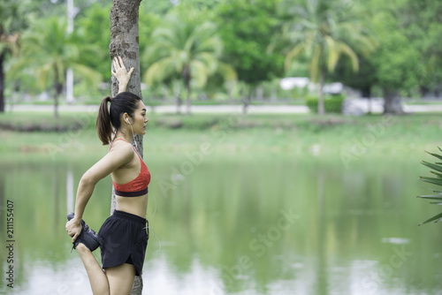 Asian sporty woman stretching body breathing fresh air in the park,Thailand people,Fitness and exercise concept,Jogging in the park