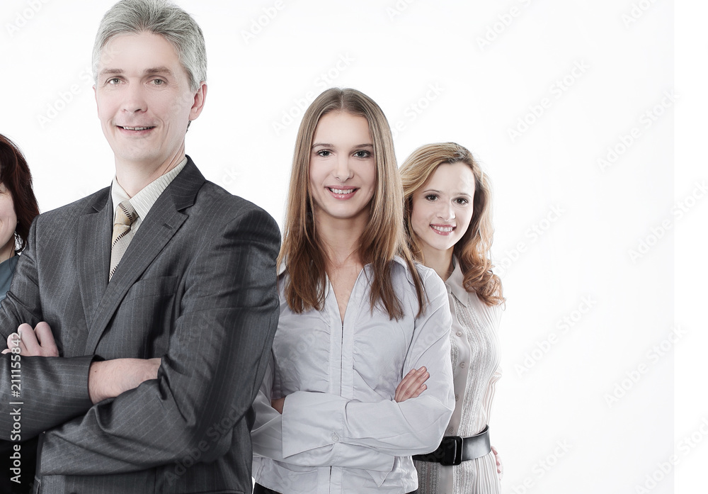 Team leader stands with coworkers in background Team leader stands with coworkers in background