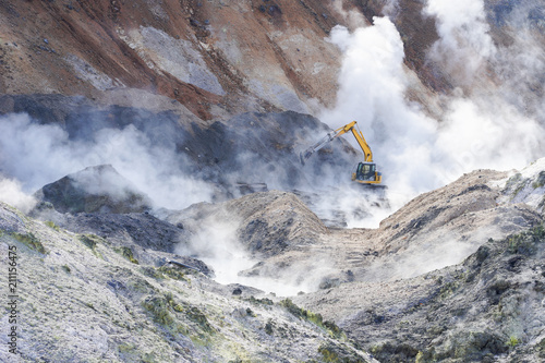 An excavator working in Jigokudani, Noboribetsu, Hokkaido. Surrounding by sulfur gas from valcano area. photo
