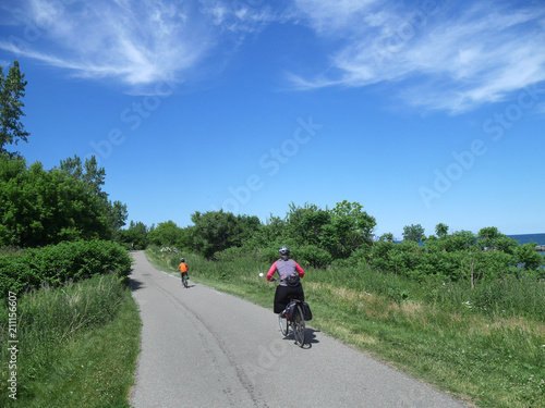 cyclists on trail beside lake