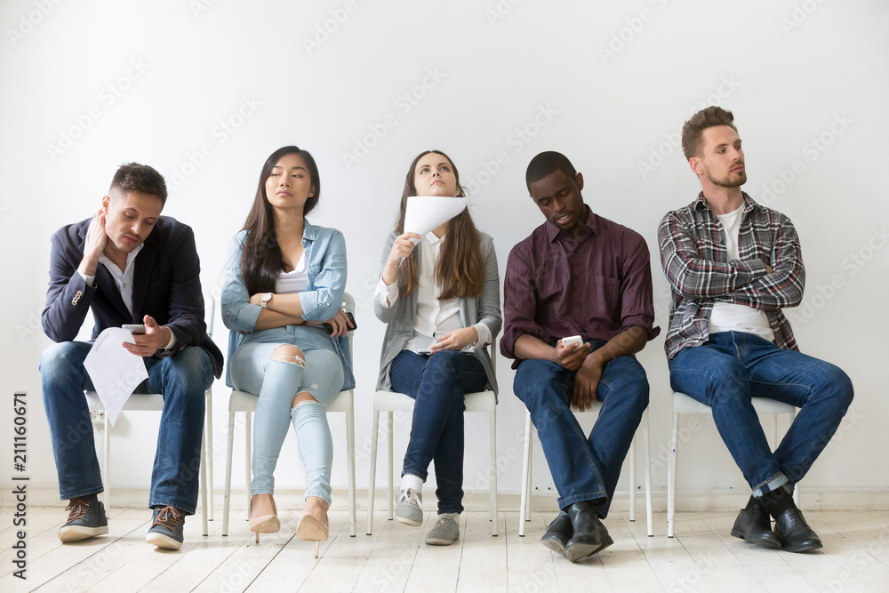 Diverse casual work candidates get bored while sitting in queue for job  interview, multiethnic applicants holding smartphones, tablets and resumes  tired of waiting. Concept of hiring, employment, HR Stock-Foto | Adobe Stock