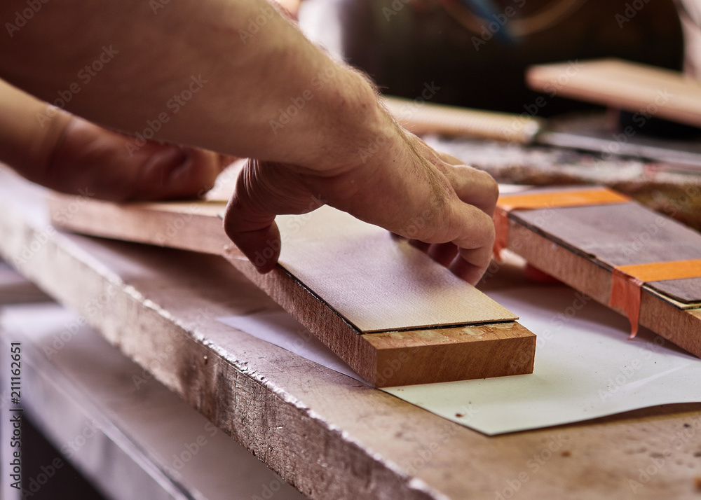 Production of classical guitar. Bonding the head plate to the head of the neck. Production of classical guitar. Bonding the head plate to the head of the neck.