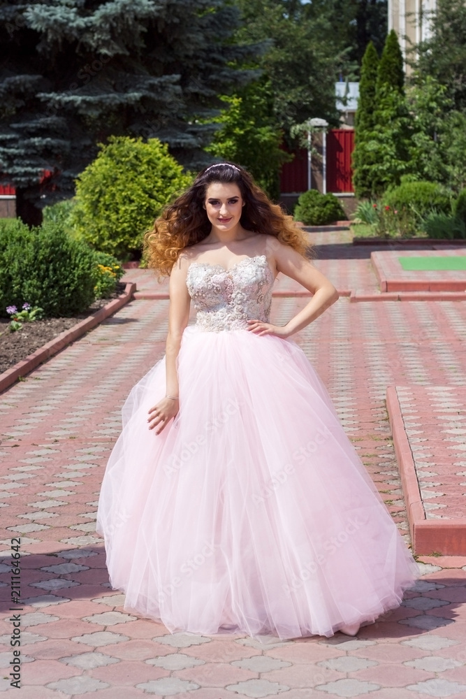 Beautiful girl in a lush pink dress
