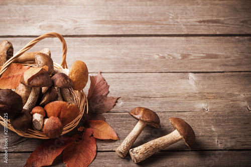 mushrooms in basket on wooden background