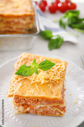 Plate with tasty lasagna on table