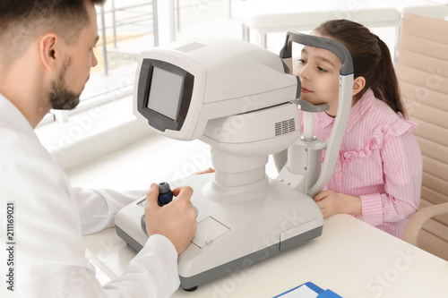 Ophthalmologist examining little girl in clinic