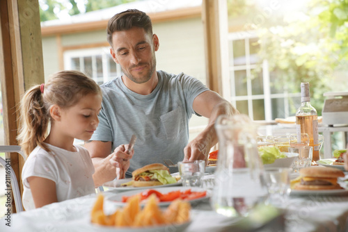 Fotografie Portrait of man with little girl eating lunch together