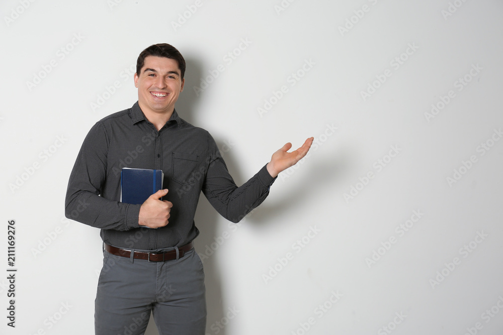 Portrait of male teacher with notebooks on light background Portrait of male teacher with notebooks on light background