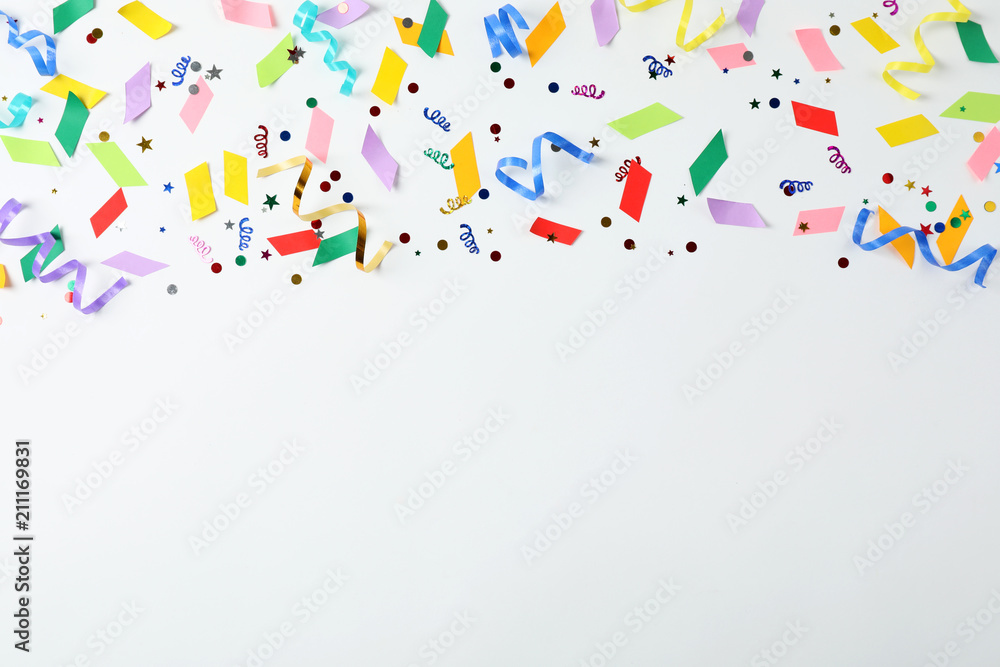 Colorful confetti and streamers on white background, top view Colorful confetti and streamers on white background, top view