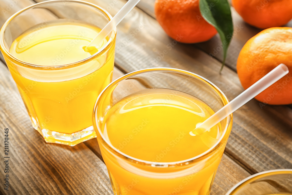 Fototapeta premium Glasses of tasty citrus juice on wooden table